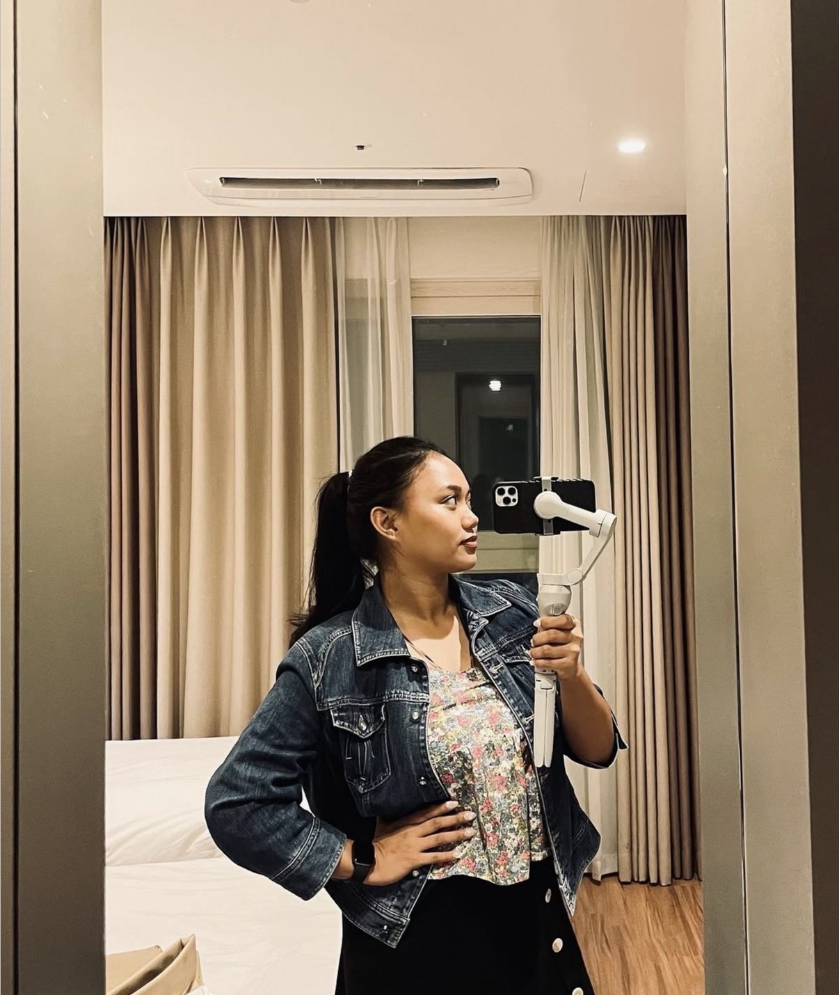 Angie filming with a phone gimbal in a hotel room mirror