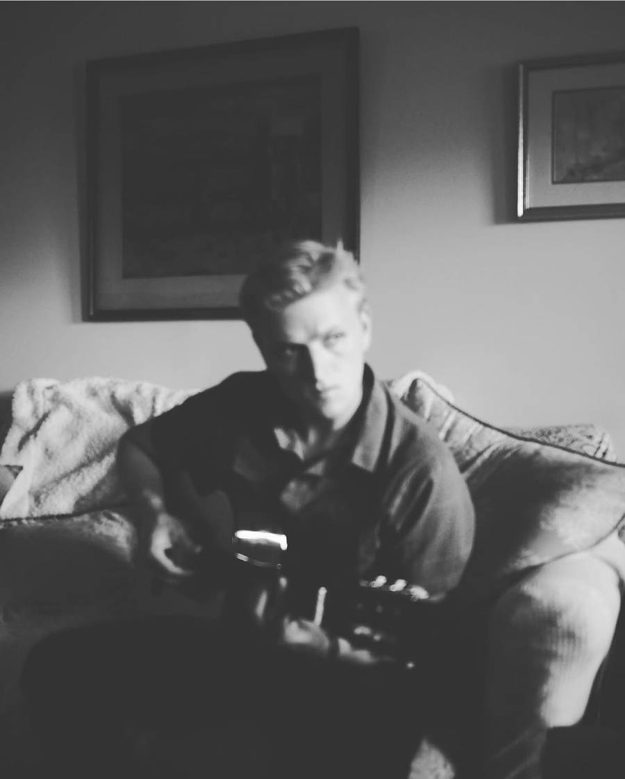 Playing guitar on a couch, black and white