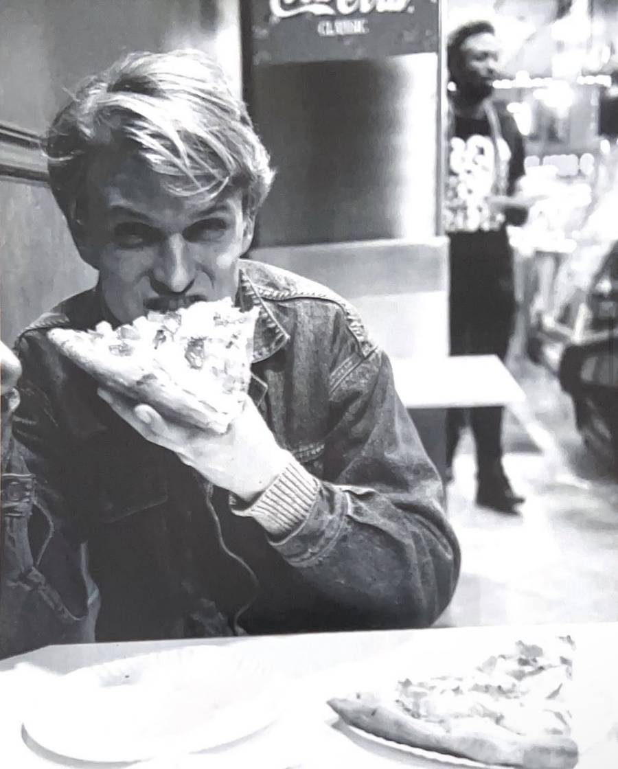 Eating a slice of pizza in a black and white photo